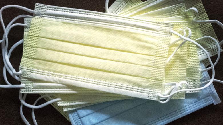 A stack of blue 和 yellow face masks. 