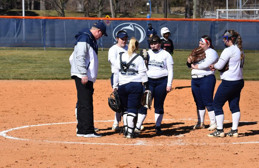 Women's softball players convene on the mound